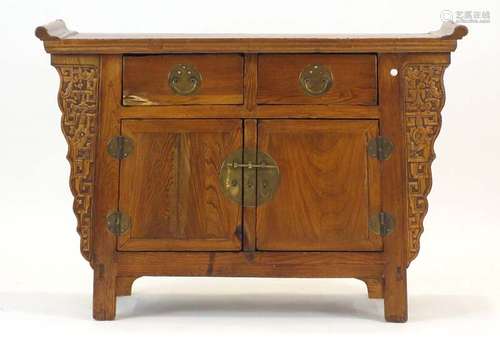 A late 19th century Chinese elm altar cabinet of typical form with two drawers above a pair of