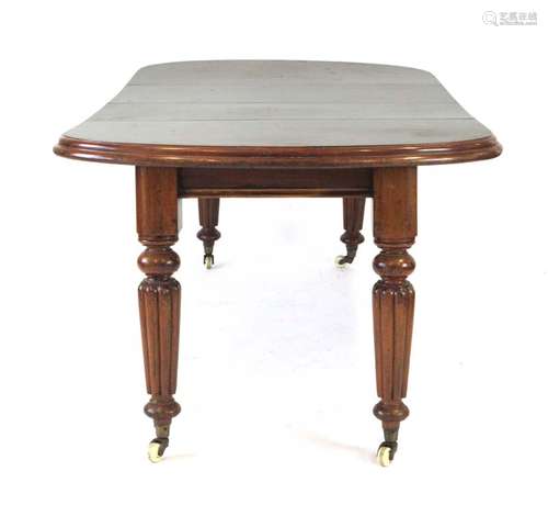 A Victorian mahogany drawer leaf extending dining table on tapered reeded legs,