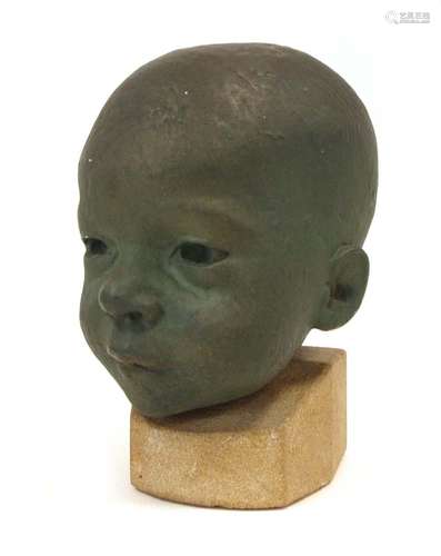 A 20th century green patinated plaster sculpture modelled as a child's head *Reputedly previously