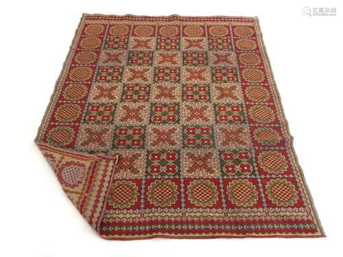 A 20th century rug decorated with repeated cross and floral medallions,