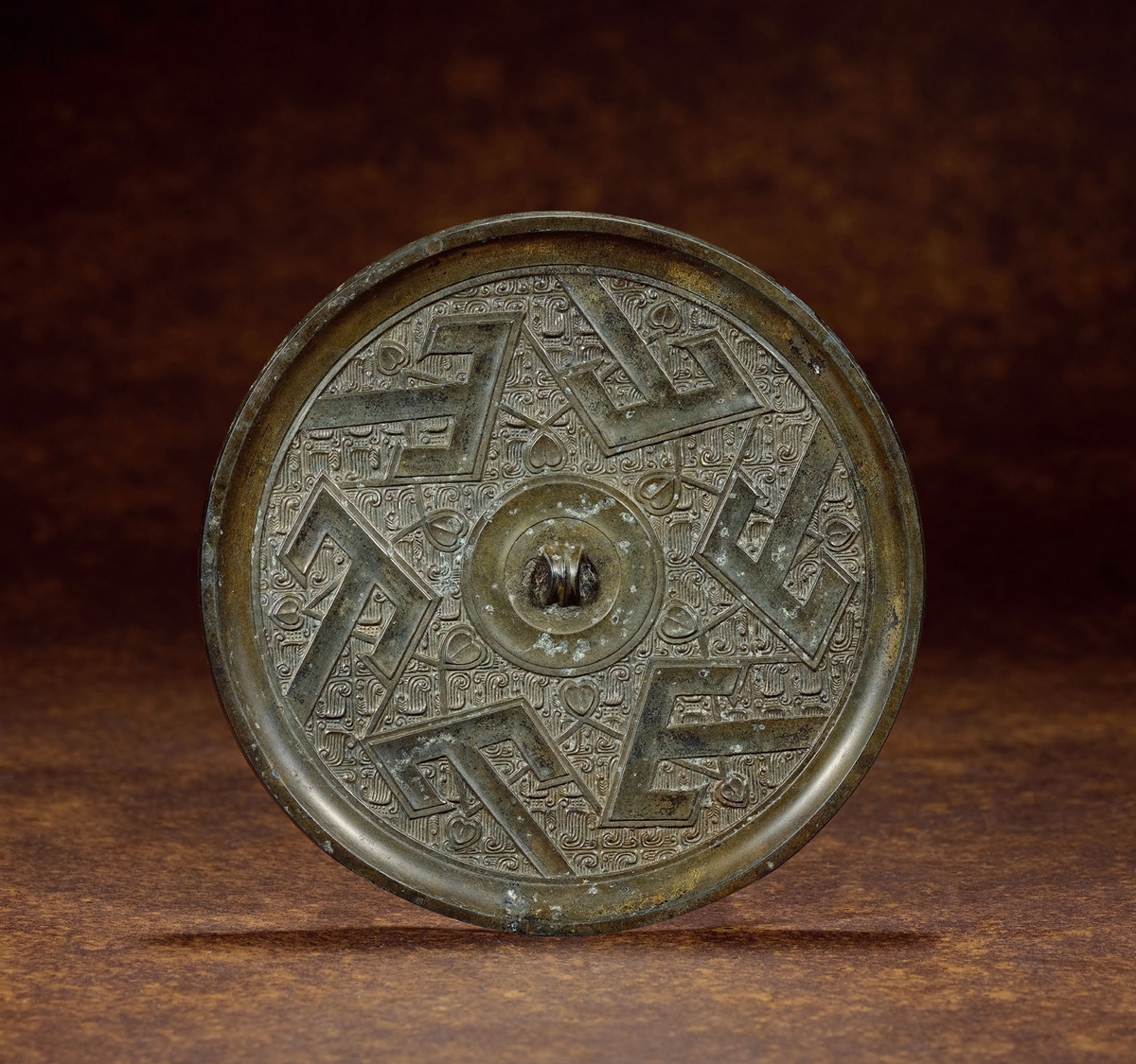 战国·青铜六山羽翅花叶镜 说明: 此镜圆形,弦纹钮,圆钮座