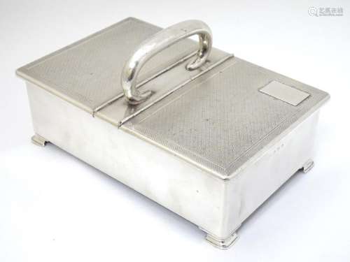 An Art Deco silver table top cigarette box with engine