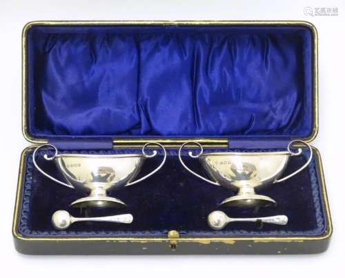 A cased pair of silver pedestal table salts. Hallmarked