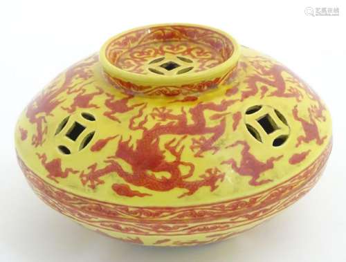 A three-footed Oriental red and yellow circular censer,