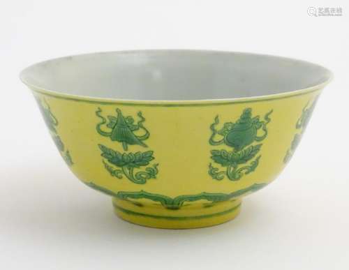 A Chinese bowl decorated with green auspicious motifs