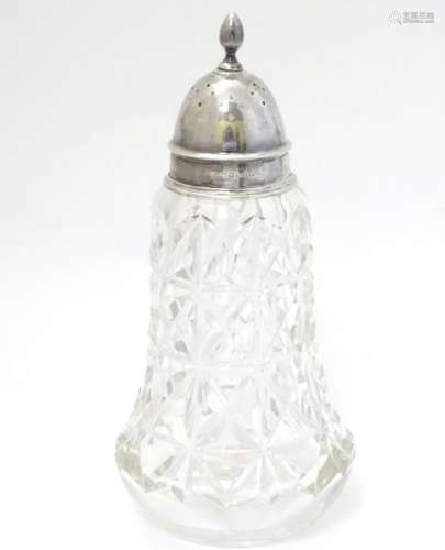 A cut glass sugar shaker / caster with silver top