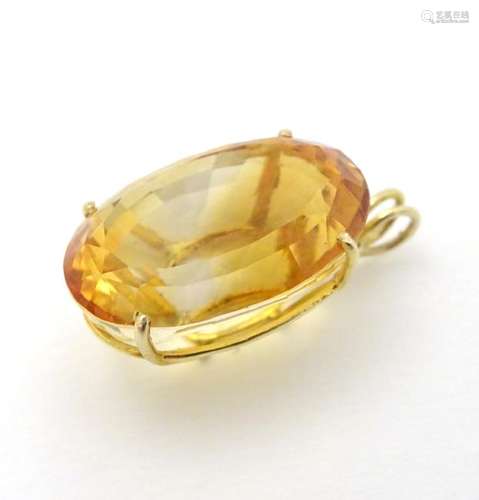 A gold pendant set with large oval yellow citrine 7/8''