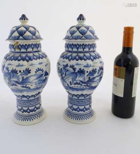 Two blue and white ginger jars decorated with buildings