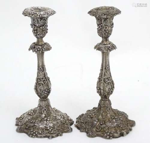 A pair of silver plate candlesticks with profuse