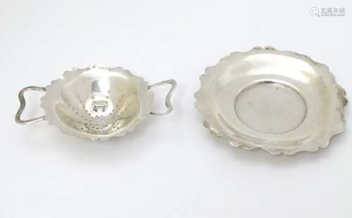 A silver tea strainer and stand hallmarked Sheffield