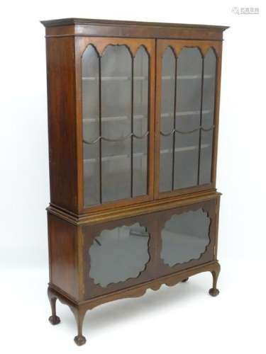 A mid 20thC mahogany glazed bookcase, having a moulded