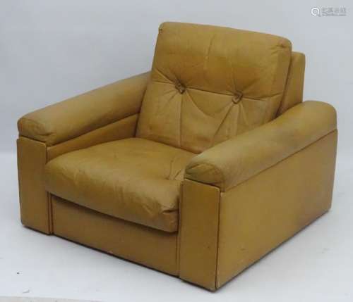 A mid / late 20thC tan leather club armchair. 32'' long