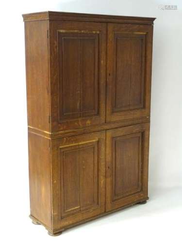 An early 19thC oak cabinet with a moulded cornice above