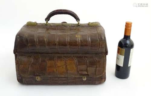 A 19thC crocodile skin travelling bag with dark purple