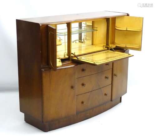 A 1930's walnut cocktail cabinet, the top opening to