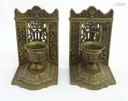 A pair of early - mid 20thC cast brass bookends, formed