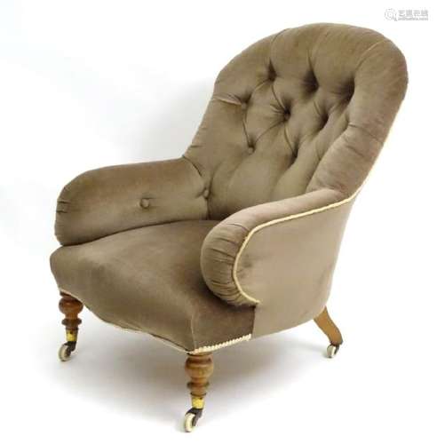 A Victorian armchair with button back upholstery and