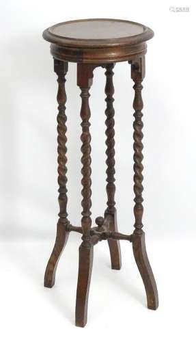 An early 20thC oak jardiniere stand with barley twist