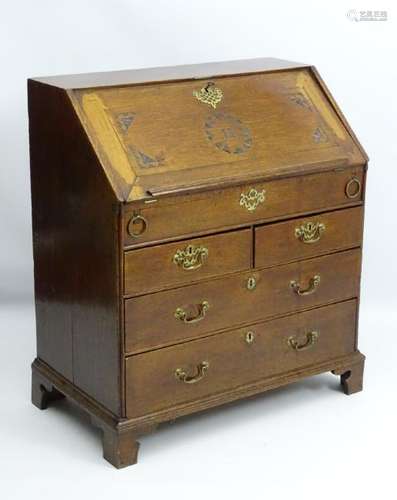 A mid 18thC oak bureau having a carved fall opening to