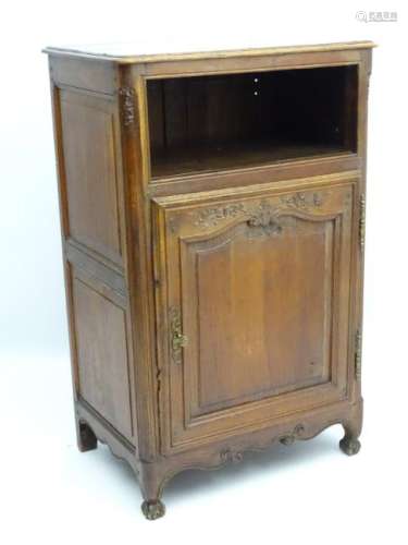 An oak Louis XV style cupboard with paneled sides and a