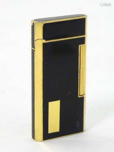 A black lacquer and gold plated Ronson roller cigarette