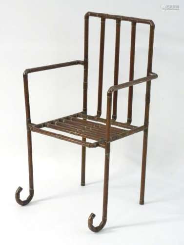A late 20thC open armchair formed from copper piping.