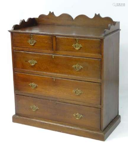 A late 19thC oak chest of drawers with a shaped