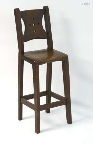 A late 19thC oak correctional chair with a pierced back