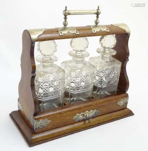 Tantalus: a c. 1900 oak and silver plate 3 bottle
