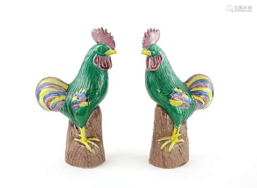 A pair of Chinese Export style figures of Cockerels; each one decorated in famille rose and