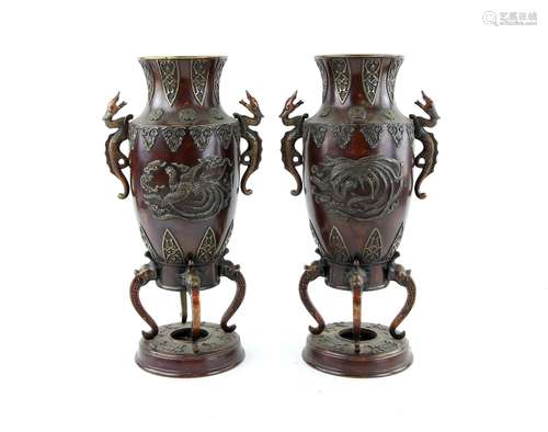 A pair of Japanese bronze vases; each one with trumpet neck and mythological animal handles,