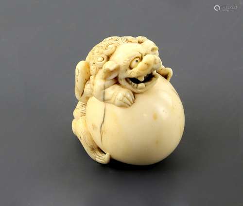 An ivory netsuke of a Karashishi on a large ball, unsigned, 19th CenturyPLEASE NOTE: THIS ITEM