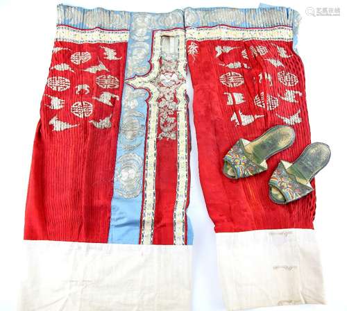 An associated pair of Chinese textile skirts; each one in scarlet and gilt with blue fringes