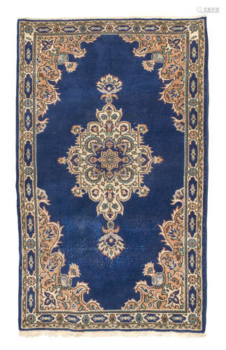 KIRMAN CARPET, MID-20TH CENTURY arabesque medallion with flowers, in the center field on blue