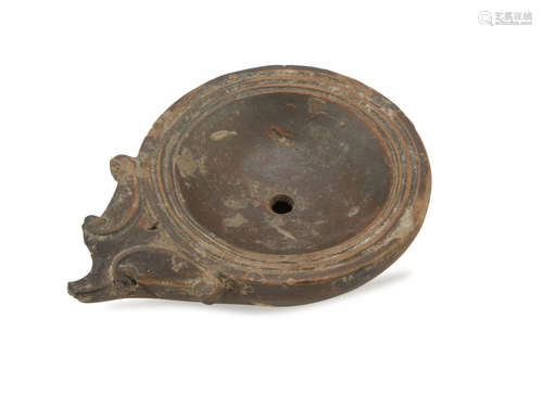 OIL LAMP IN EARTHENWARE, 1st-3rd CENTURY in rosy clay, varnished in brown. Damaged. Measures cm. 4 x