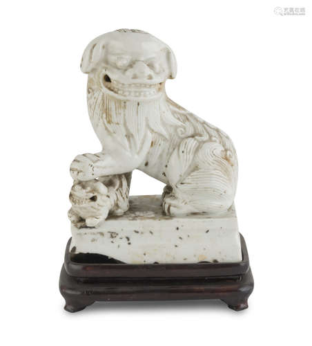 WHITE PORCELAIN SCULPTURE, CHINA 19TH CENTURY representing a Buddhist lion in protective pose.