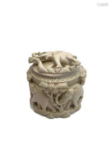 An Indian ivory tea caddy, circa 1900-1920, the oval cover and body carved with elephants and trees,