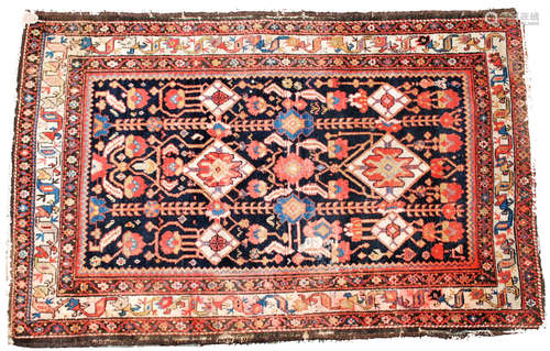 A North West Persian rug, the indigo field with linked lozenge medallions, palmettes,