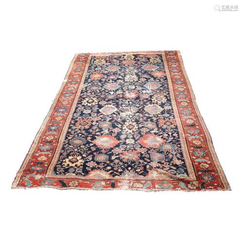 A Persian carpet, the indigo field with an all over design palmettes and flowering vines,