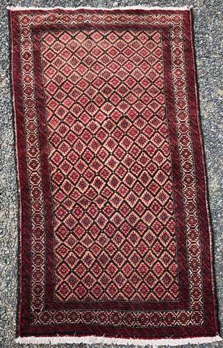 A Belouch rug, the camel field with rows of diamond motifs enclosing serrated guls,