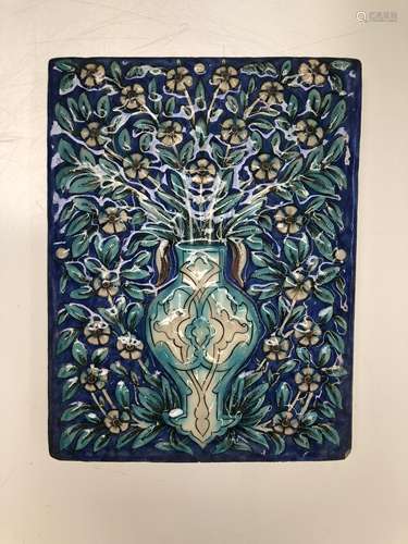 A Persian pottery tile, Qajar period, depicting a vase of flowers on a blue ground, 29 x 22cm.