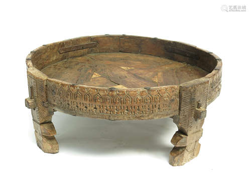 An Indian wooden circular table, with a carved solid gallery on four shaped legs, height 30cm,