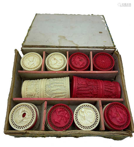 A set of thirty two Chinese carved ivory draughts counters, with associated ivory shakers and box,