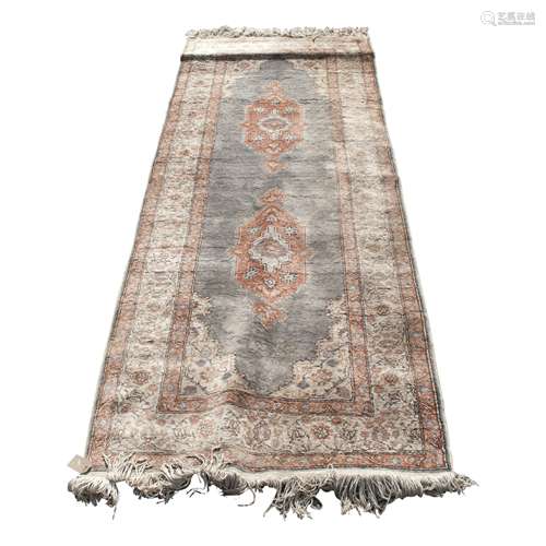 A Turkish Kayseri rug, the indigo field with two polychrome medallions each with flowering vines,