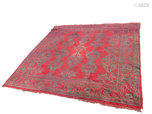 An Ushak 'Turkey Red' carpet, the madder field with rows of linked polychrome skeletal medallions,