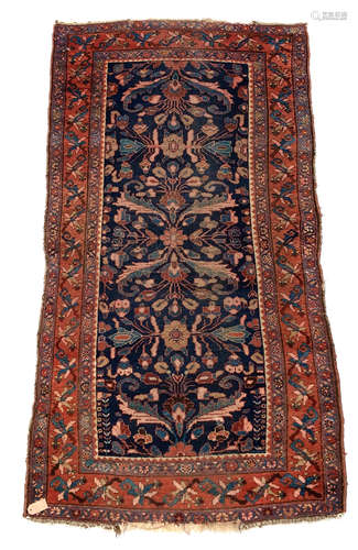 A Hamadan rug, North West Persia, the indigo field with an all over design of serrated leaves,