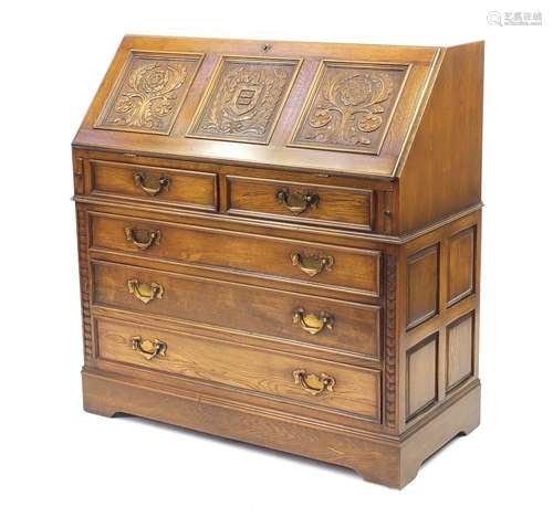 Jaycee oak bureau, carved with a crest and Tudor rose, fitted with a fall and fitted interior