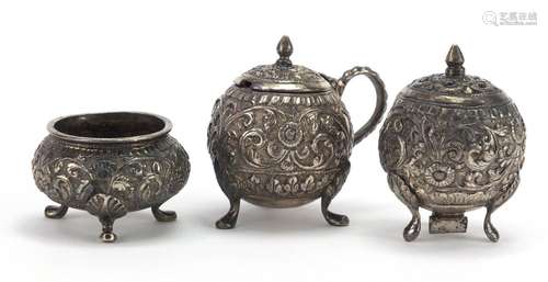 Indian unmarked silver three piece cruet, embossed with flowers, the largest 5.5cm high, approximate