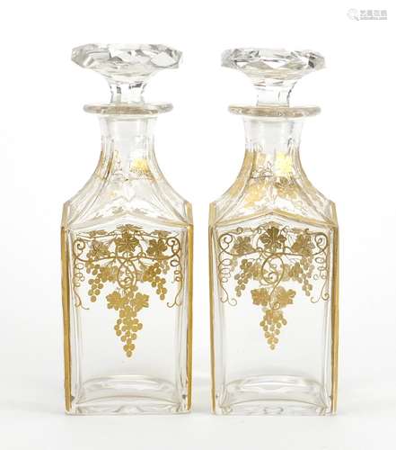 Pair of 19th century continental glass decanters, gilded with leaves and berries, each 20.5cm high :