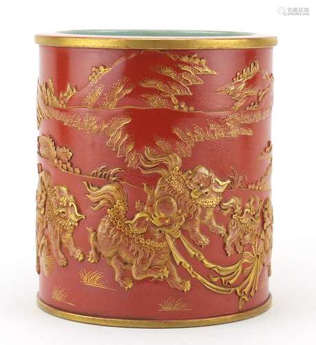 Chinese porcelain iron red brush pot, decorated in relief and gilded with qilins in a landscape,